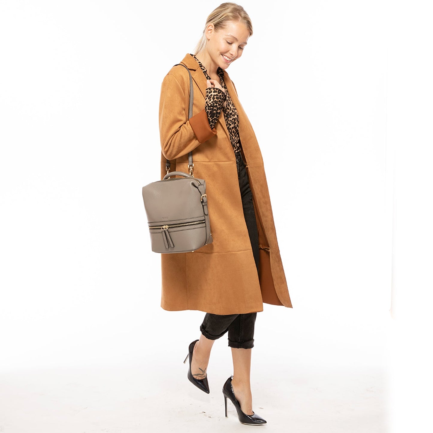 SUSU convertible backpack worn as crossbody bag showing detachable strap configuration