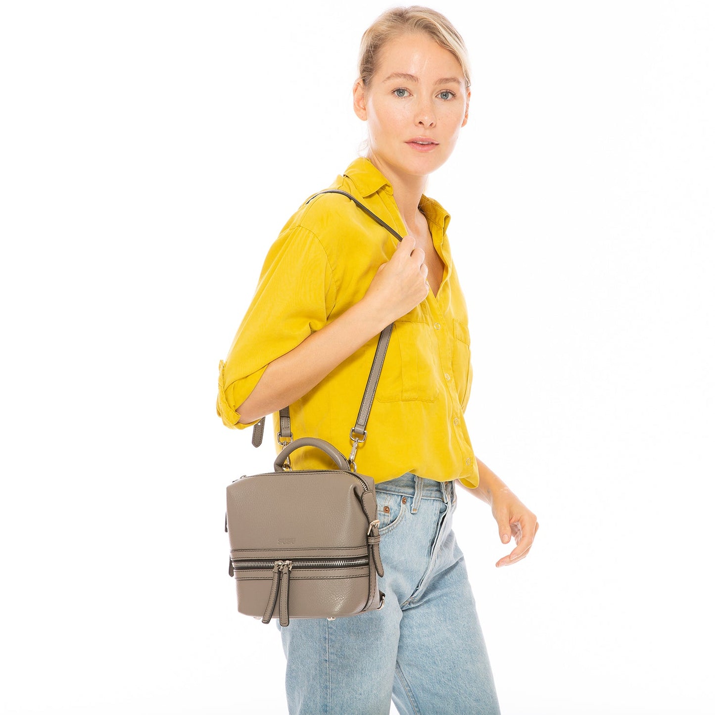 SUSU convertible backpack worn as crossbody bag showing adjustable strap configuration