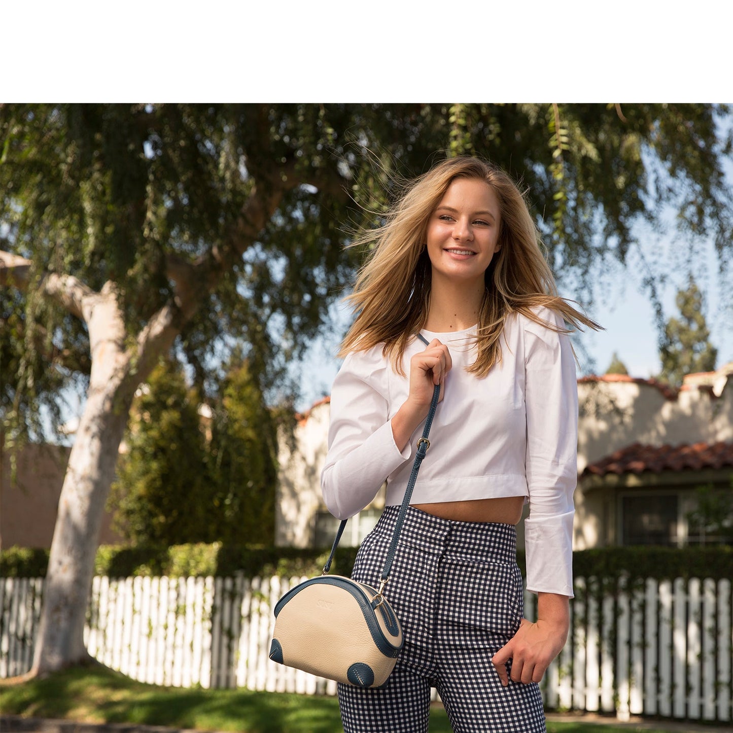 Woman wearing SUSU Coco ivory crossbody bag showing crossbody styling