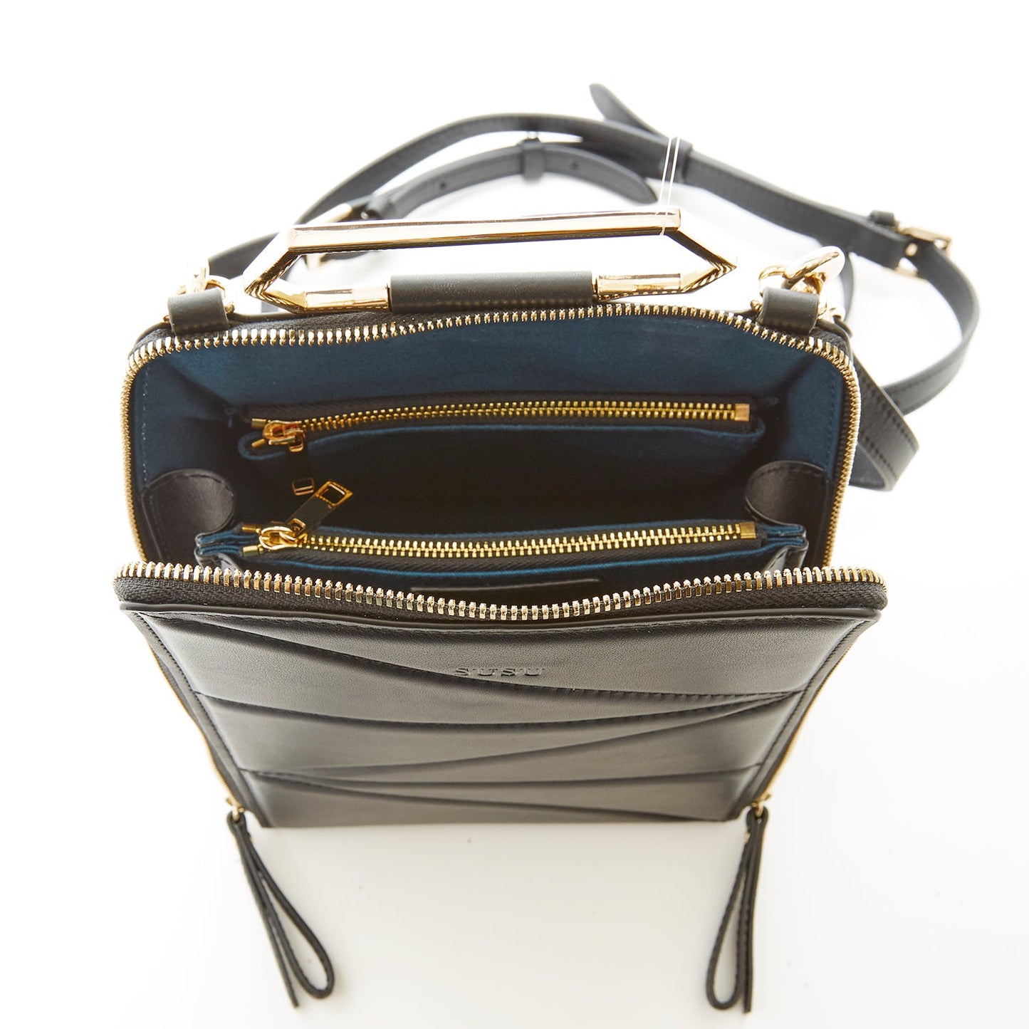 SUSU black leather backpack interior view with teal fabric lining and 3 compartments