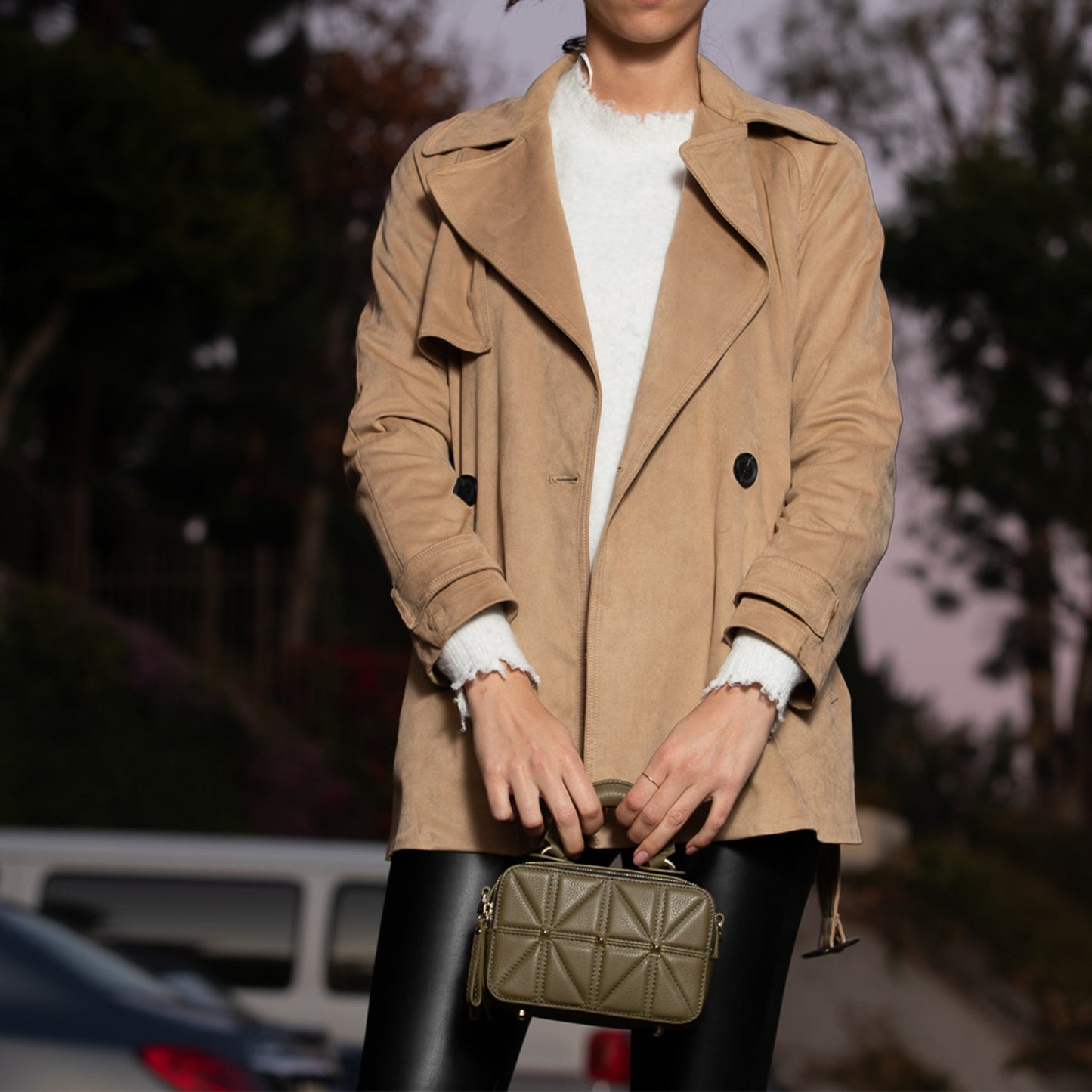 SUSU Taylor quilted leather bag carried by top handle showing gold hardware