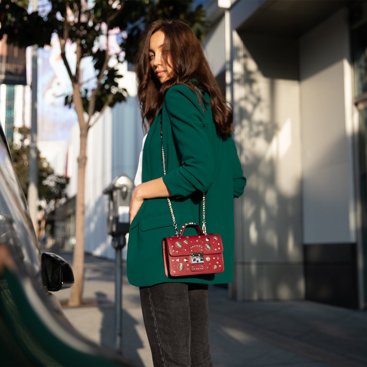 Woman wearing SUSU burgundy studded crossbody bag showing style and fit