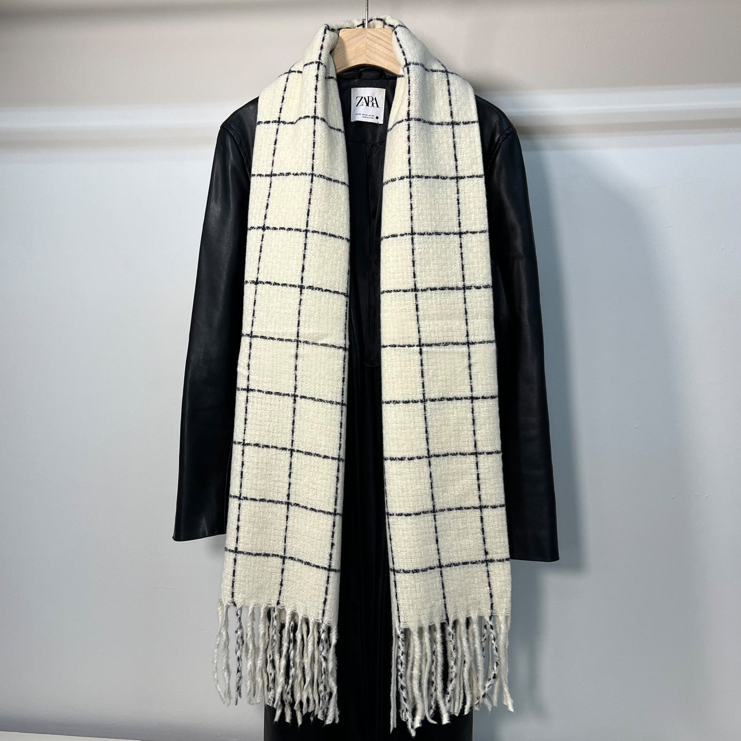 SUSU plaid scarf draped showing elegant fringe trim and soft texture